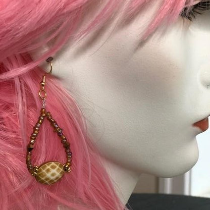 golden dangler earrings and pink hair