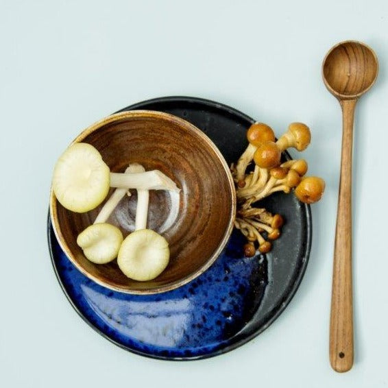mushrooms in ceramic bowl and wooden spoon