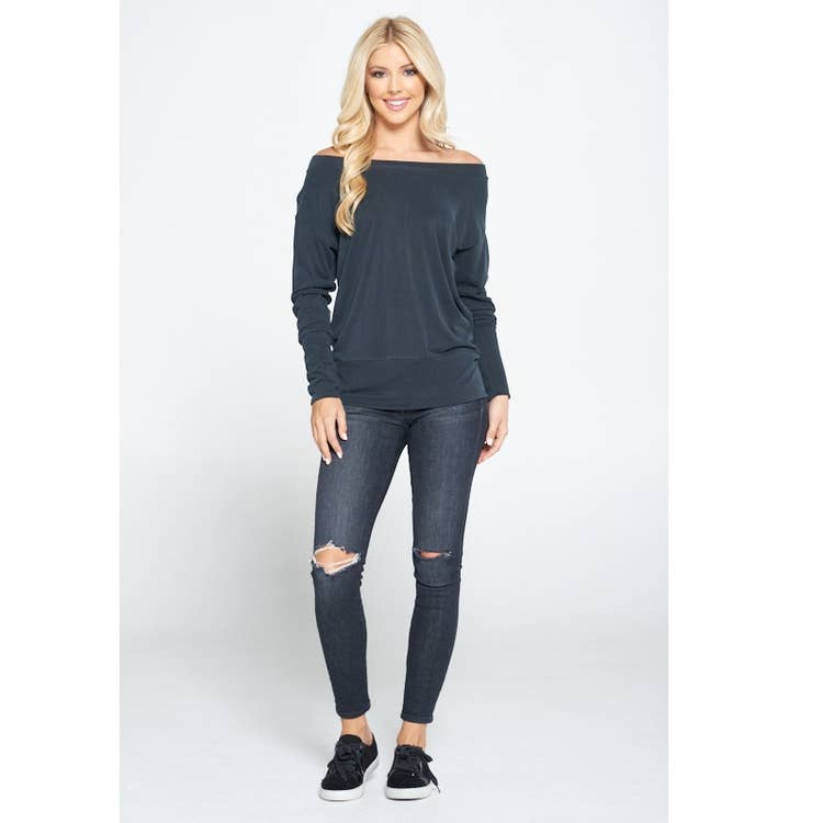 blond lady with ripped jeans, sneakers and casual wear off shoulder sweater in black