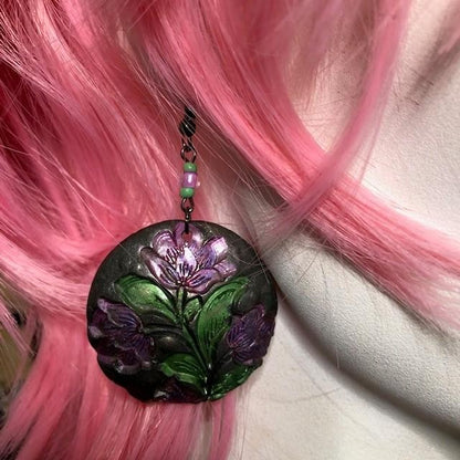 purple flower with green leaf on a black round earring dangler