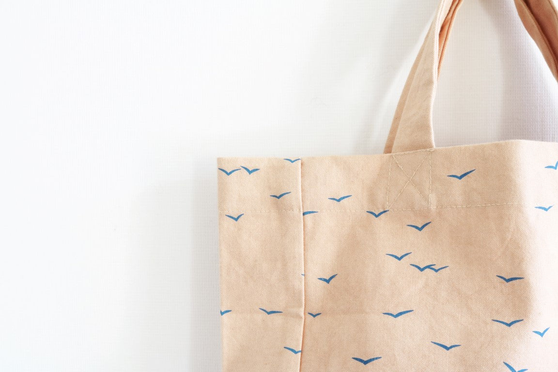 detail of cotton bag in nude with blue birds